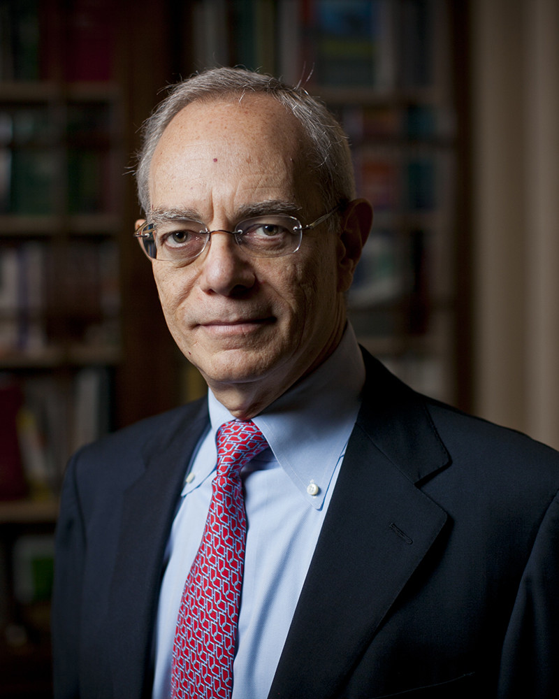 MIT President Rafael Reif in his office standing in front of bookshelves