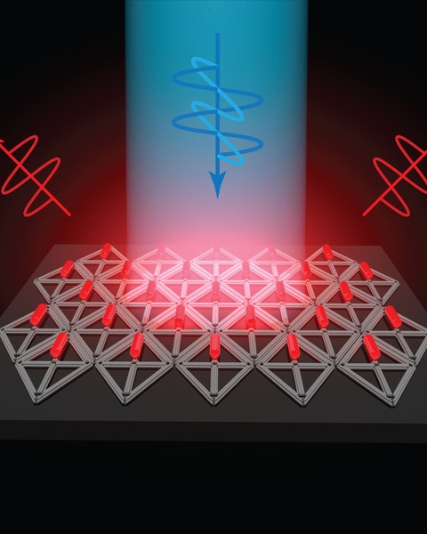 A blue squiggle-like DNA graphic points down in the center emitting light downwards. Two red DNA graphics are pointed up beside it. A structured array composed of triangular rods lie flat on dark gray surface, while the top rows of the arrays contain pieces resembling red pills.