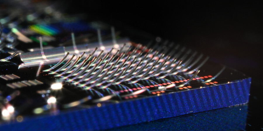 Photonic chip covered in microscopic structures that curl upward
