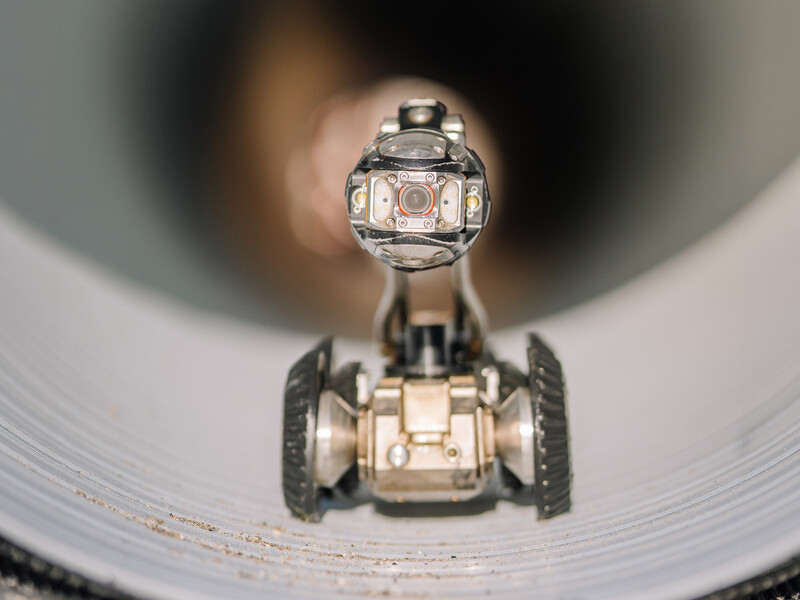 A tiny robot on wheels inside a tube
