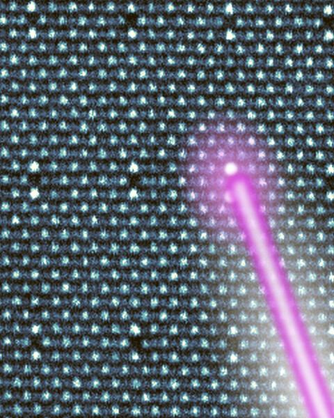 A laser beam lights up a specific atom in a giant crystal lattice of atoms.