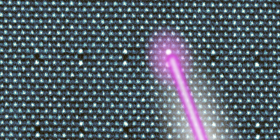 A laser beam lights up a specific atom in a giant crystal lattice of atoms.